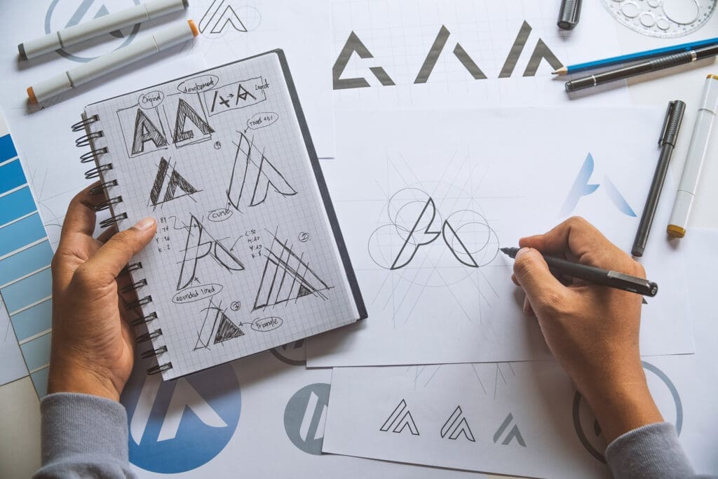 Thom Baker Consultancy What is brand strategy? Designer working on "A" logos